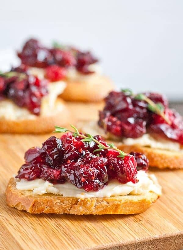 Cranberry sauce dolloped on crispy crostini with a sprinkle of parmesan and thyme for a fancy appetizer